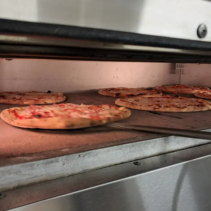 Pizze tonde in cottura sulla pietra del forno