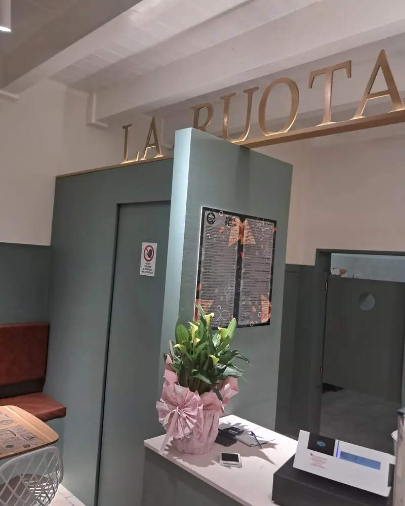 L'insegna dorata La Ruota sopra il bancone, all'interno del locale